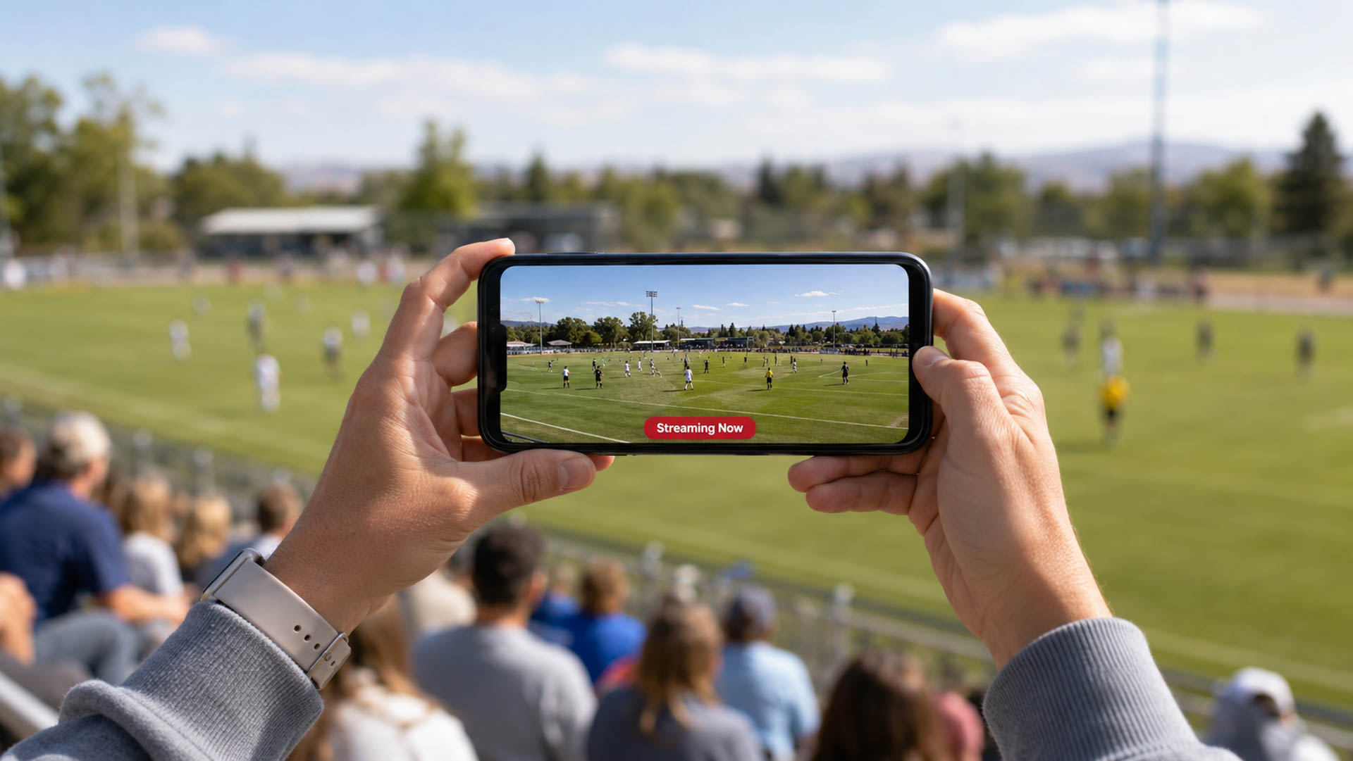 A parent filming their child's game from the stands